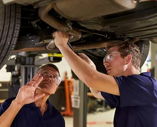 onteur die werkt aan de uitlijning van een autoband met behulp van gespecialiseerd gereedschap