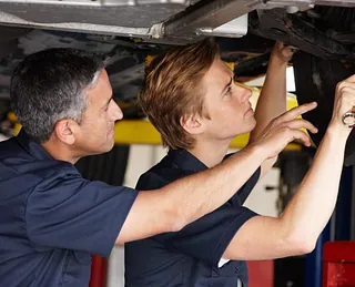 onteur die werkt aan de uitlijning van een autoband met behulp van gespecialiseerd gereedschap